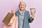 Senior grey-haired woman holding shopping bags and australia dollars smiling with a happy and cool smile on face