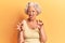 Senior grey-haired woman wearing casual clothes smiling funny doing claw gesture as cat, aggressive and sexy expression