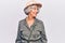 Senior grey-haired woman wearing explorer hat looking away to side with smile on face, natural expression