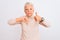 Senior grey-haired woman wearing turtleneck sweater standing over isolated white background Doing thumbs up and down, disagreement