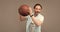 senior grizzled man with basketball ball on grey background, sport