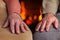 Senior hands resting near the fireplace