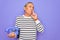 Senior handsome grey-haired man holding vintage handset telephone over purple background serious face thinking about question,