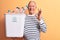 Senior handsome grey-haired man recycling holding wastebasket full of plastic bottles doing ok sign with fingers, smiling friendly