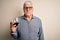 Senior handsome hoary man drinking glass of red wine over isolated white background with a confident expression on smart face