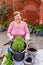 Senior happy caucasian woman transplanting lavender seedling