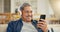 Senior, happy man and headphone for video call in living room by internet, web or app. Elderly person, smile and