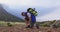 Senior hiker man with backpack tying his shoe laces while trekking in the mountains.