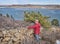 senior hiker at old stone fence overlooking frozen mountain lake