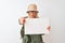 Senior hiker woman wearing canteen hat holding banner over isolated white background pointing with finger to the camera and to