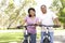 Senior Hispanic Couple Riding Bikes In Park