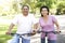 Senior Hispanic Couple Riding Bikes In Park