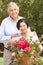 Senior Hispanic Couple Working In Garden Tidying Pots