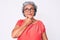 Senior hispanic grey- haired woman wearing casual clothes and glasses with hand on chin thinking about question, pensive