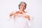 Senior hispanic grey- haired woman wearing casual clothes smiling in love doing heart symbol shape with hands