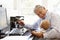 Senior Hispanic man with computer and baby