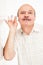 Senior hispanic man with glass kistening to the gossips through the wall