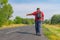 Senior hitchhiker walking on a roadside