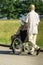 Senior husband pushing wife in wheelchair