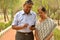 Senior Indian Bengali couple in park looking at their smart phone and smiling in a park in New Delhi, India. Concept love