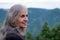 Senior Indian woman with grey hair and glowing skin, meditating in the morning.