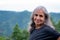 Senior Indian woman with grey hair and glowing skin, meditating in the morning.