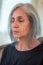 Senior Indian woman with grey hair and glowing skin, meditating in the morning.