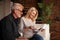 Senior joyful husband and wife look at the mail. Paper work together. A nice bonus for a mature couple