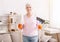 Senior lady holding mop and broom and smiling