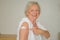 Senior lady pointing to a plaster on her arm covering her vaccination site