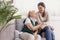 Senior lady sitting in armchair at nursing home, supporting nurse