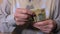 Senior male counting dollars banknotes, poverty, social insecurity, close-up