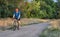 Senior male cyclist is riding a touring bike on a gravel trail