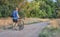 Senior male cyclist is riding a touring bike on a gravel trail