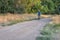 Senior male cyclist is riding a touring bike on a gravel trail