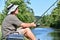 Senior Male Fisherman Sitting With Rod And Reel Outdoors