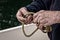 Senior Male Hands Tying Rope on a Boat