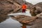 senior male paddler with a decked expedition canoe with a wooden paddle on a rocky shore of Horsetooth Reservoir