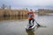 senior male is paddling stand up paddleboard on a lake in Colorado