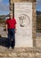 Senior male tourist by the Monument to Cabo da Roca being the westernmost point of Europe, on the Atlantic Ocean in Portugal.