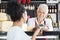 Senior Man Accepting Payment From Customer In Cheese Shop