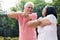 Senior man assisting his wife during warming up exercises outdoo