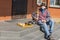 Senior man with basenji male dog wearing masks sitting on a  threshold, reading book and playing chess