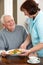 Senior Man Being Served Meal By Carer