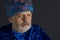 Senior man in blue oriental clothes against dark background