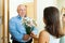 Senior man came to mature woman with flowers