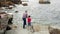 Senior man with child throwing fishing rod to the sea