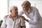 Senior man clinic patient interacting with nurse in white coat