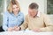 Senior Man Completing Sudoku Number Puzzle With Teenage