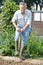 Senior Man Digging Vegetable Patch On Allotment